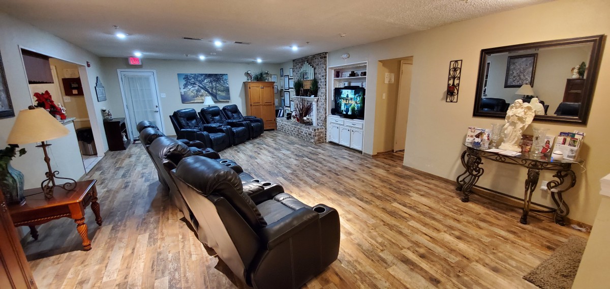 A spacious living room with comfortable recliner chairs and a home theater setup.