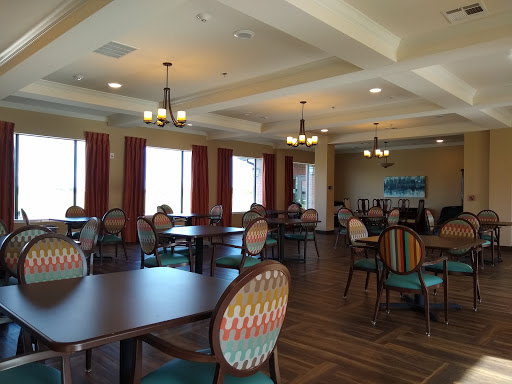 A spacious dining area with decorative chairs and ambient lighting, creating a warm atmosphere.