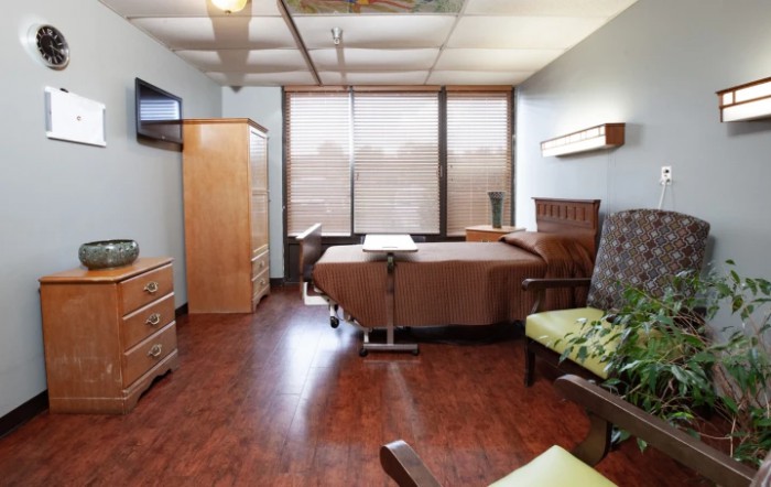 A cozy hospital room with a patient bed and comfortable furnishings.