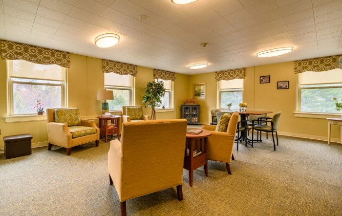 A cozy living room with comfortable seating and natural light from multiple windows.