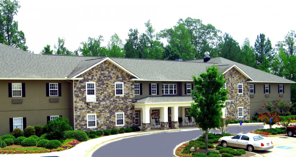 A large two-story house with a stone exterior and a landscaped driveway.