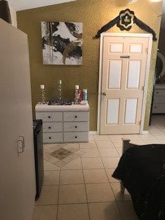 A cozy room interior featuring a dresser with candle holders and a closed door.