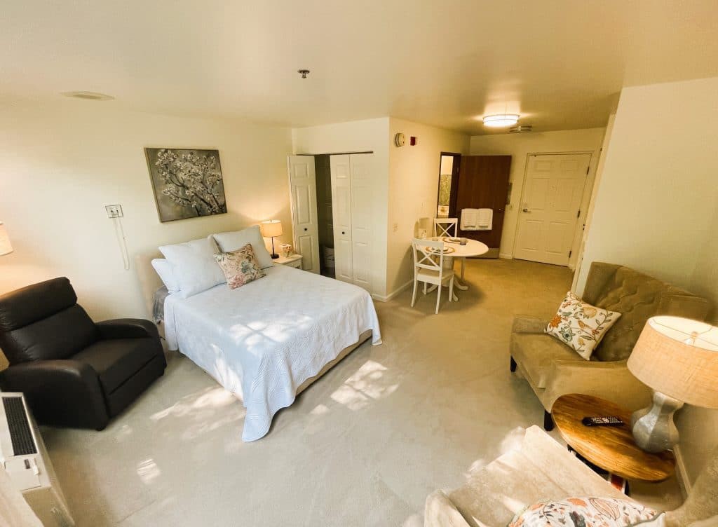 A cozy apartment interior with a neatly arranged bedroom and living area.