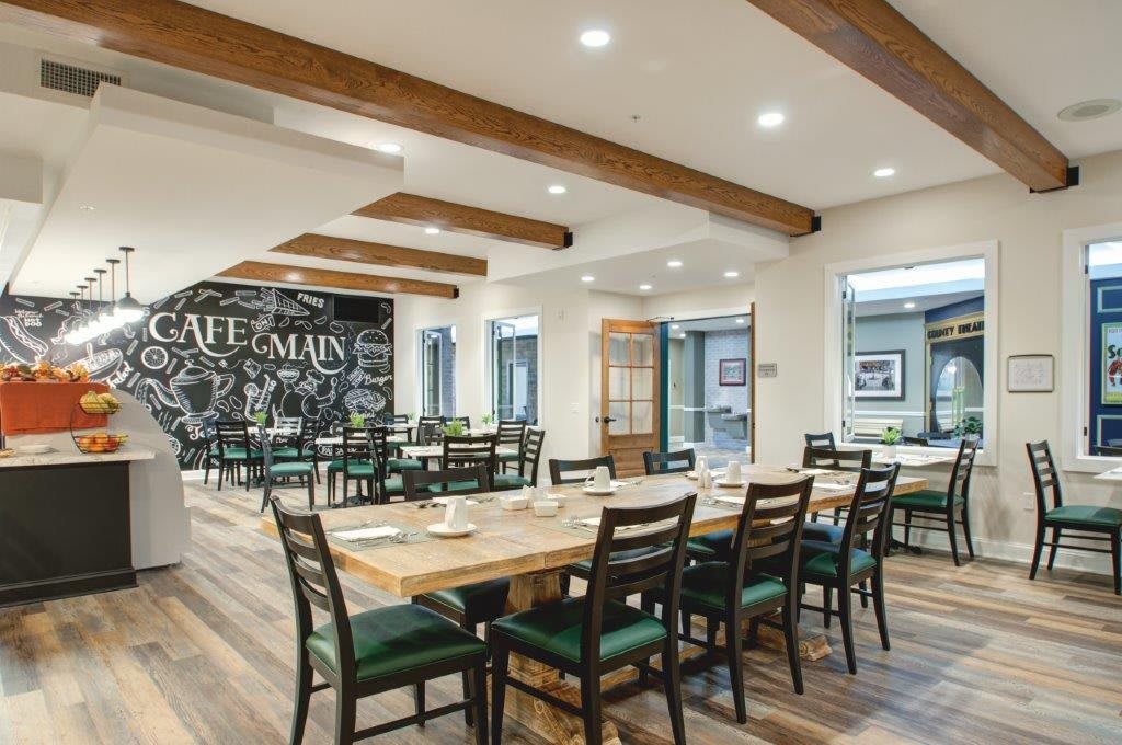 A modern restaurant dining area featuring wooden beams and neatly arranged tables and chairs.