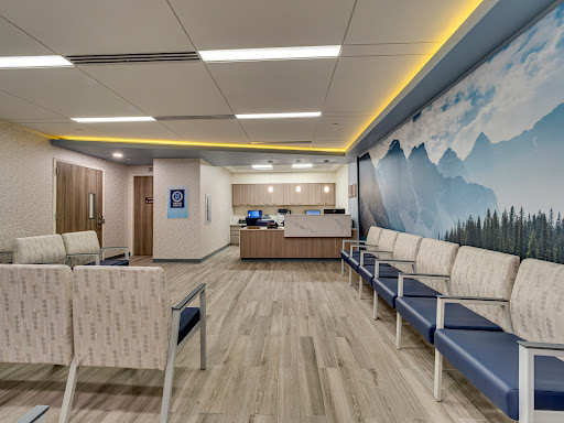 A modern and inviting hospital waiting room with comfortable seating and a calming mural.