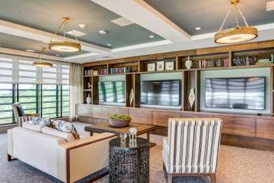 A modern living room with a large TV, stylish furniture, and decorative shelving.