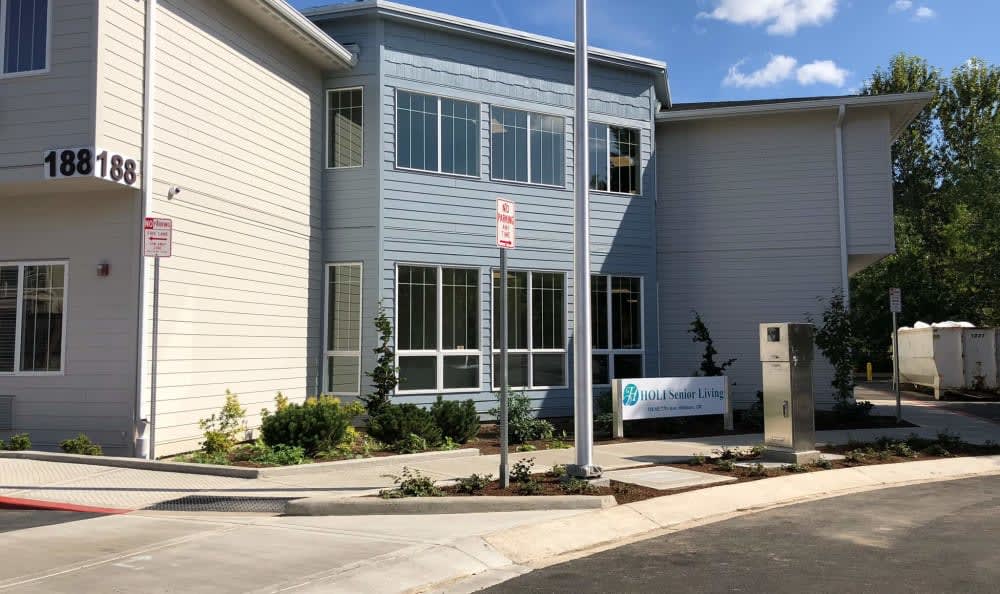 A modern office building with a well-maintained entrance and clear blue skies above.