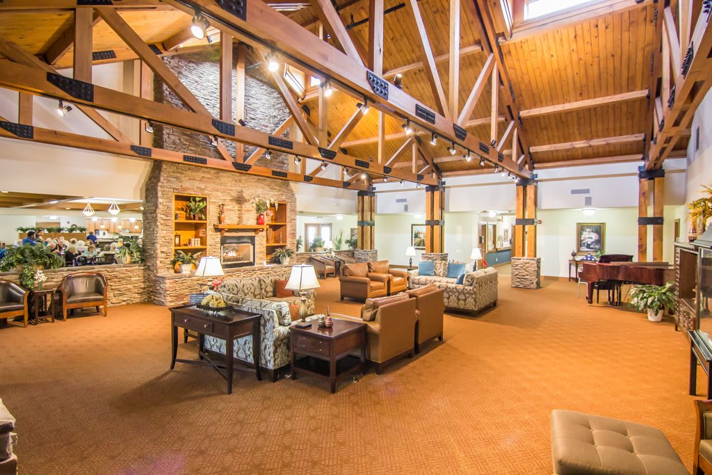 A spacious lodge interior featuring wooden beams and comfortable seating areas.