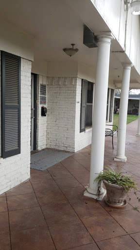 A welcoming entrance featuring a white brick exterior and a porch with columns.