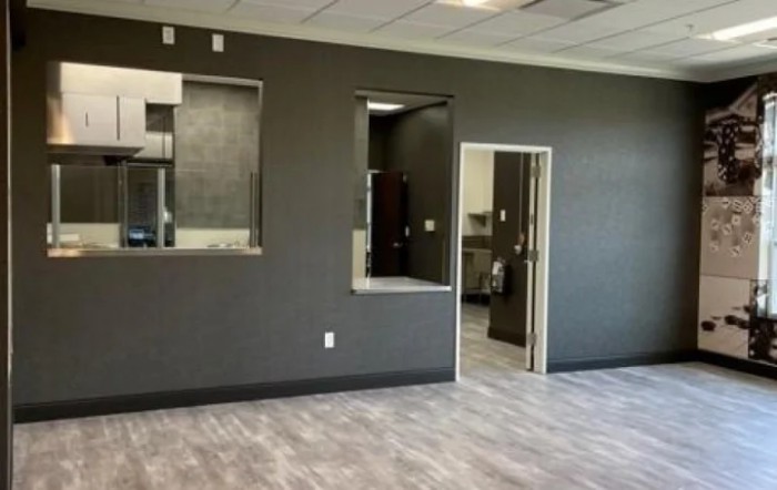 An empty office space with gray walls and modern flooring.