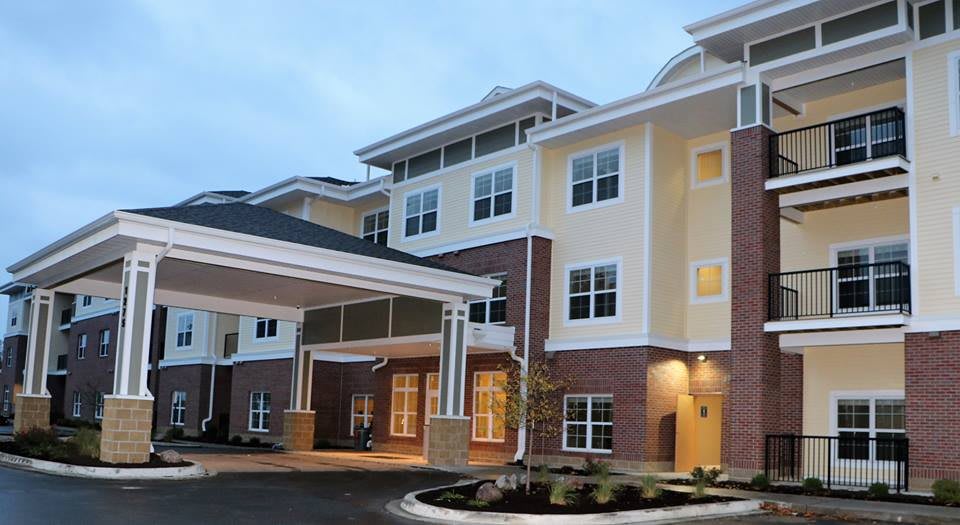 A modern residential building with multiple stories and a covered entrance.