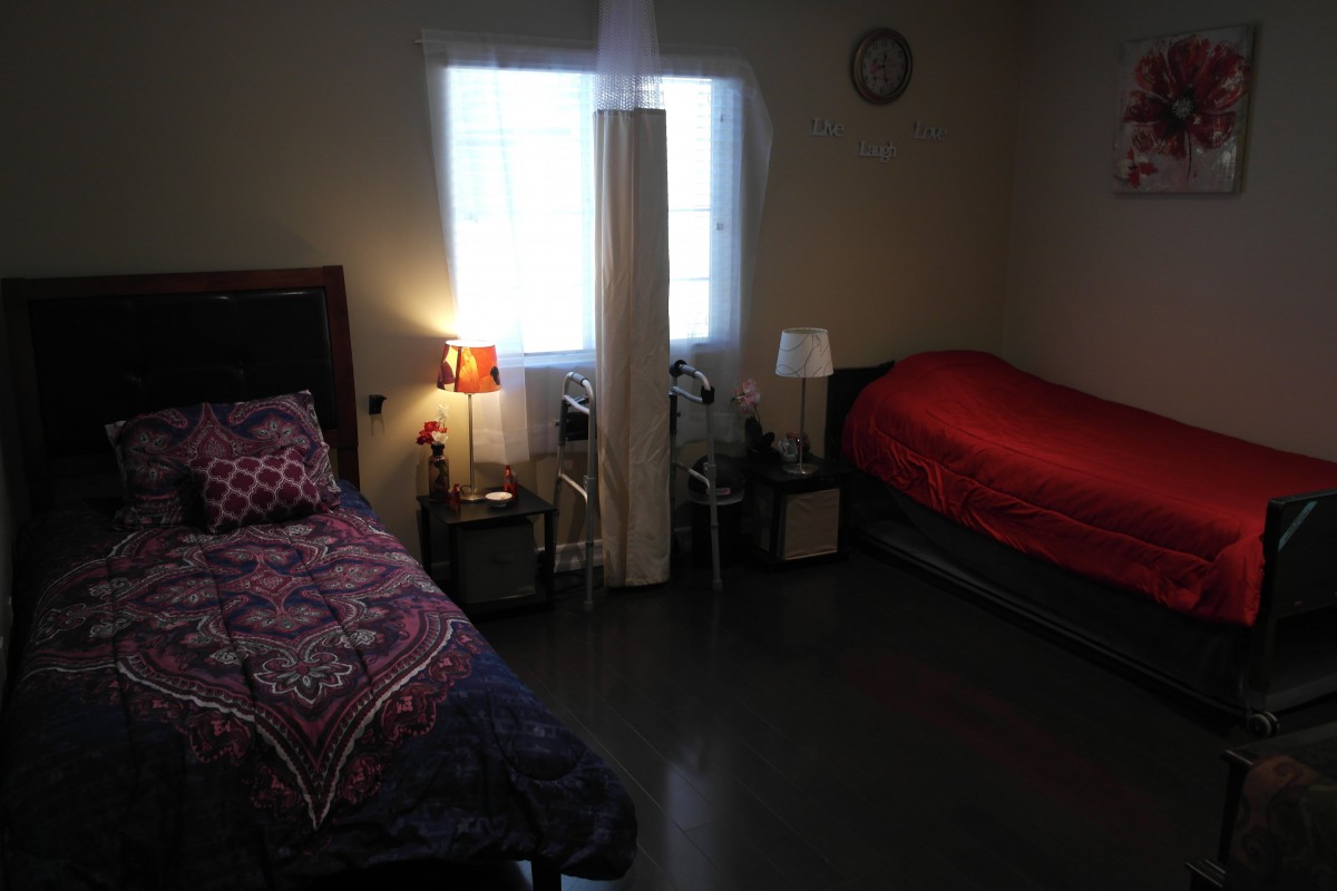 A cozy bedroom with two beds and dim lighting from lamps.