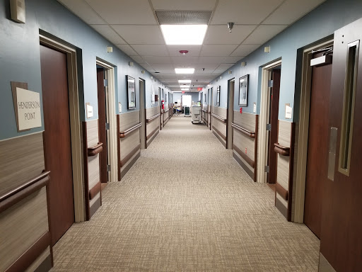 A view of a hospital hallway lined with patient rooms.