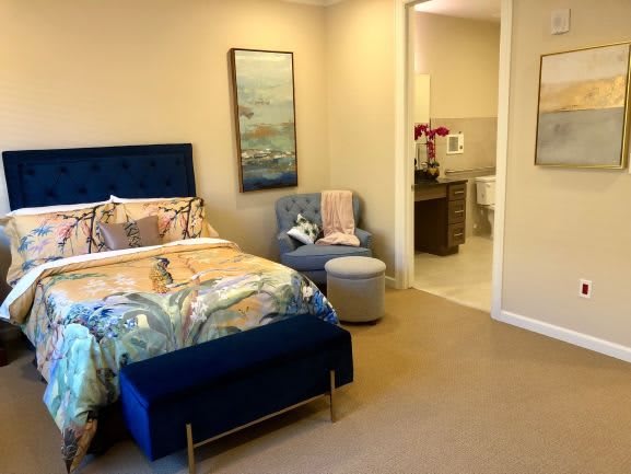 A cozy bedroom with modern blue accents and a connected bathroom.