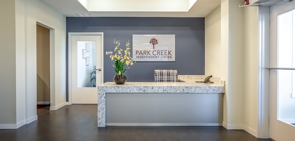 A modern reception desk at Park Creek featuring a floral arrangement and stylish decor.