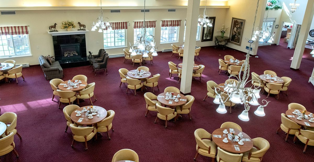 An overhead view of an empty dining area with neatly arranged tables and chairs on a carpeted floor.