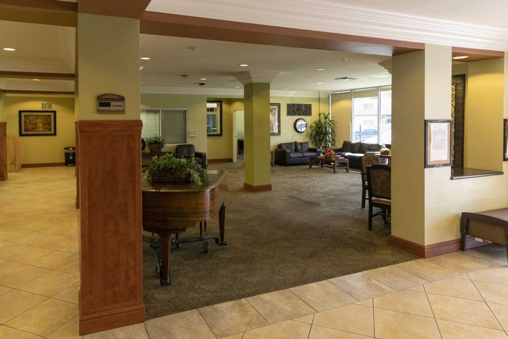 A spacious lobby area with seating, tables, and natural light.