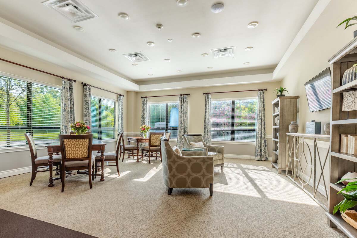 A spacious and well-lit living room with comfortable seating and large windows.