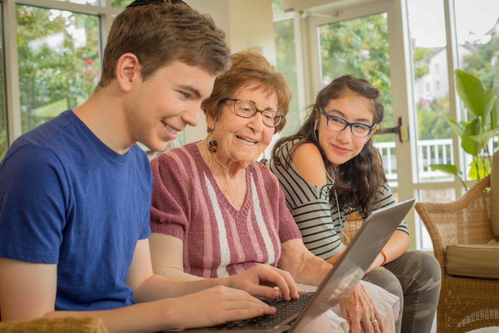 A multigenerational family learning together using a laptop.
