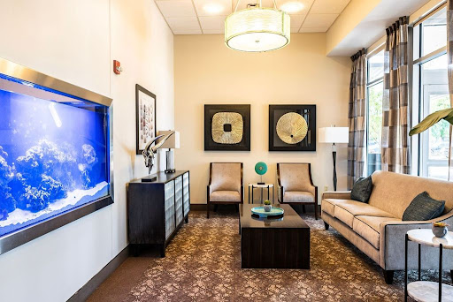 A modern and cozy living room setting featuring comfortable seating, decorative artwork, and a television.