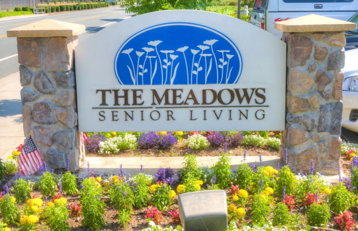 The Meadows Senior Living entrance sign with colorful landscaping.