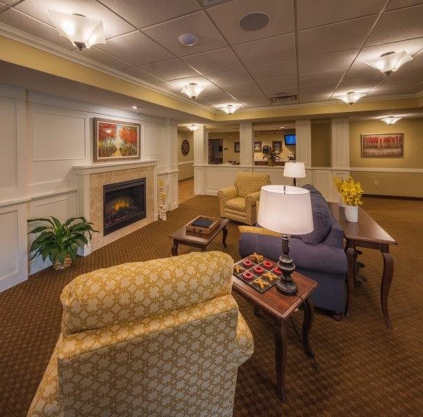 A cozy living room with comfortable seating and a fireplace, featuring elegant decor.