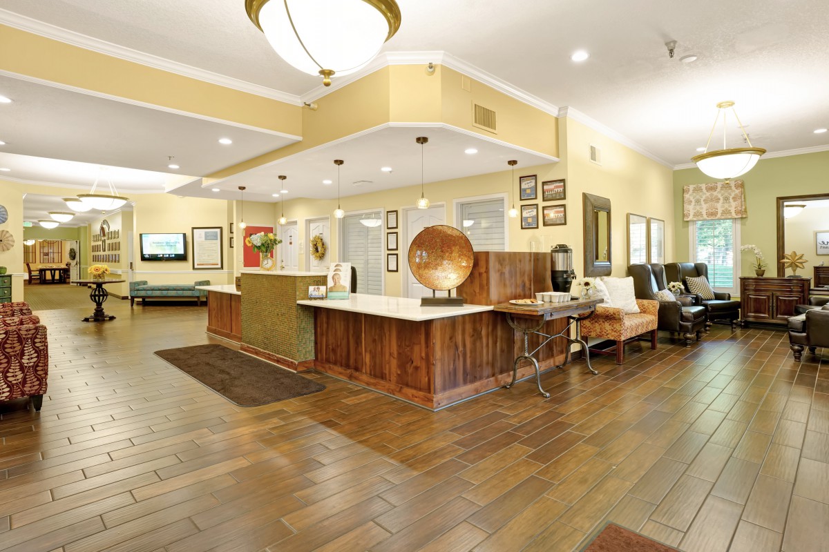 A spacious lobby with a wooden reception desk, stylish decor, and comfortable seating.