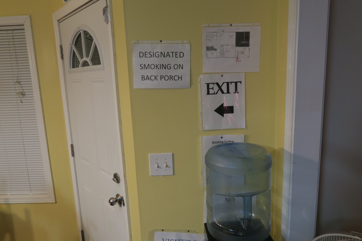 An indoor scene with a door, exit signs, and a water cooler.
