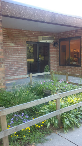 Entrance to a brick building surrounded by green landscaping.