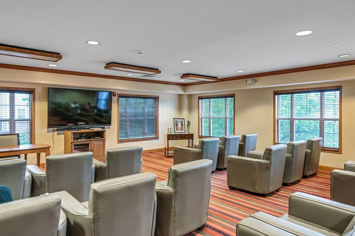 A cozy theater room with comfortable seating and a large television.