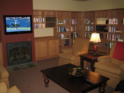 A cozy living room with bookshelves, a television, and comfortable seating.