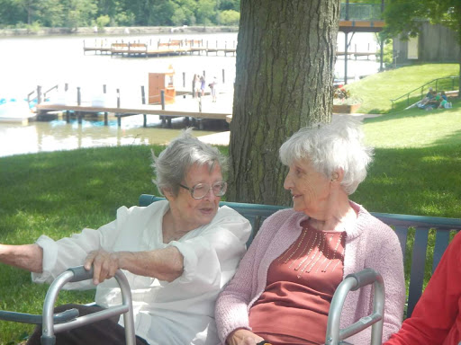 Two elderly women enjoying a peaceful moment together in a park.
