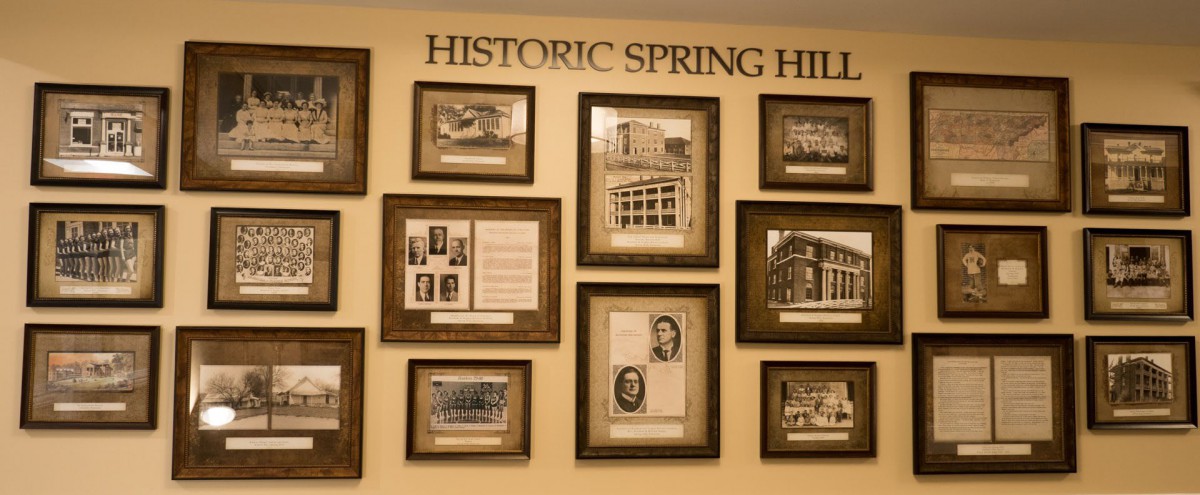 A wall exhibit displaying various historic photos and documents of Spring Hill.