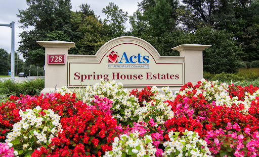 Entrance sign of Spring House Estates surrounded by vibrant flower beds.