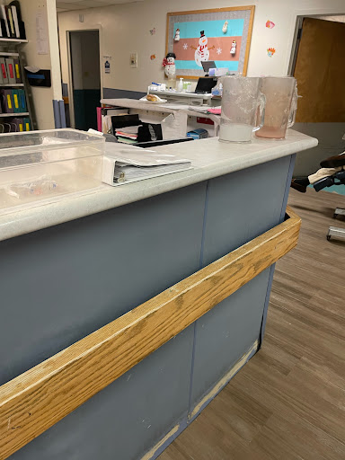 A reception desk featuring a wooden barrier and various office supplies.