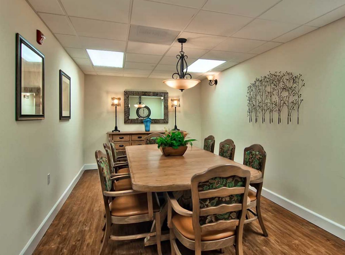 A cozy dining room with a wooden table and chairs, featuring elegant decor and ambient lighting.