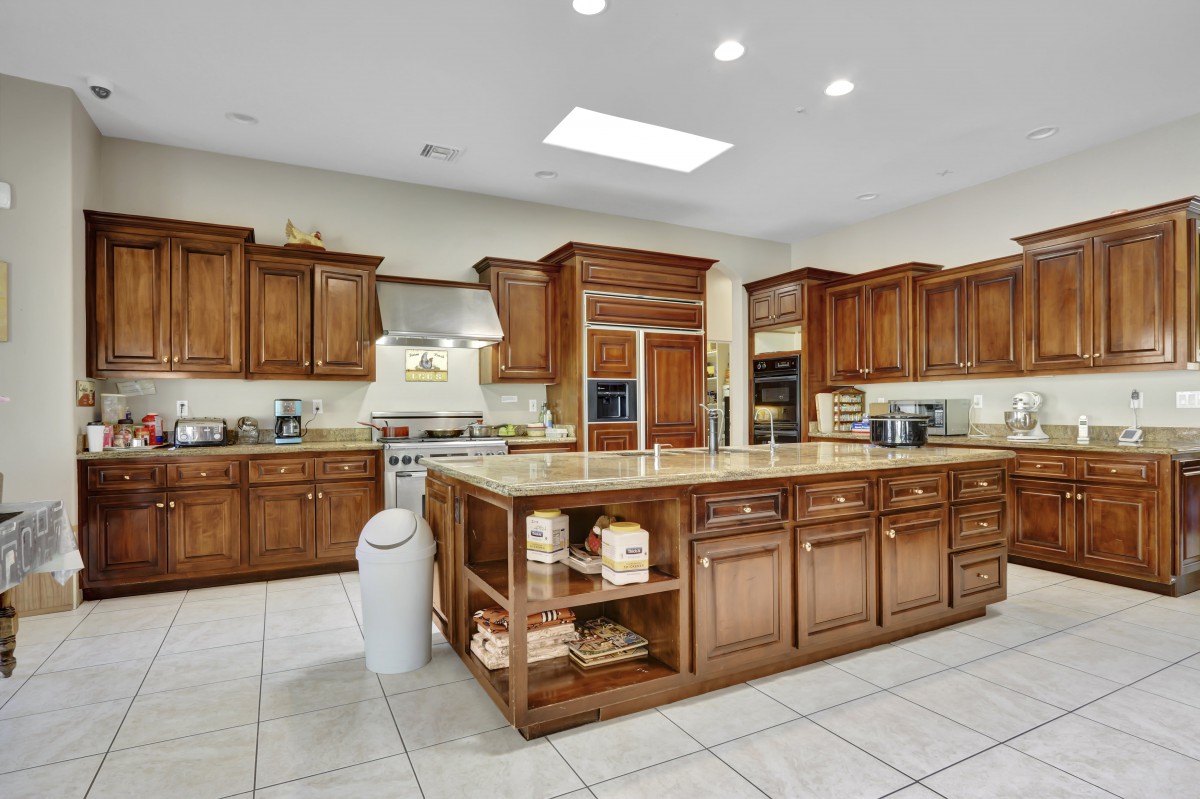 A spacious modern kitchen with wooden cabinets and a central island.