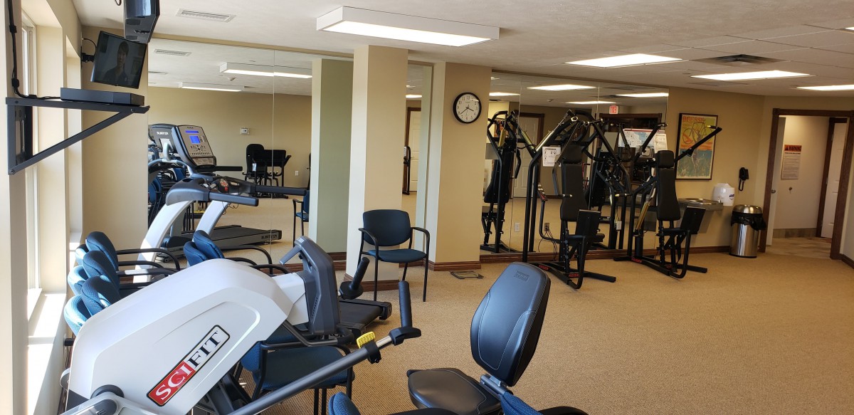 A well-equipped gym with various exercise machines and fitness equipment.