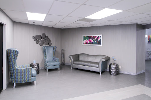 A modern waiting area featuring stylish gray furniture and decorative wall art.