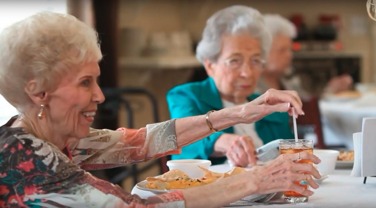 Elderly women enjoying a meal together in a community setting.