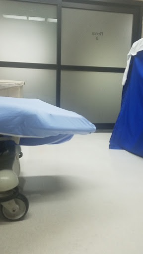 An examination room in a medical facility with a blue examination table.