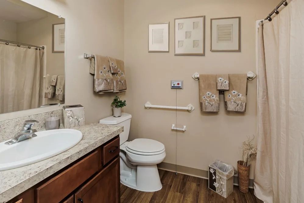 A well-decorated bathroom with a toilet, sink, and towels organized neatly.