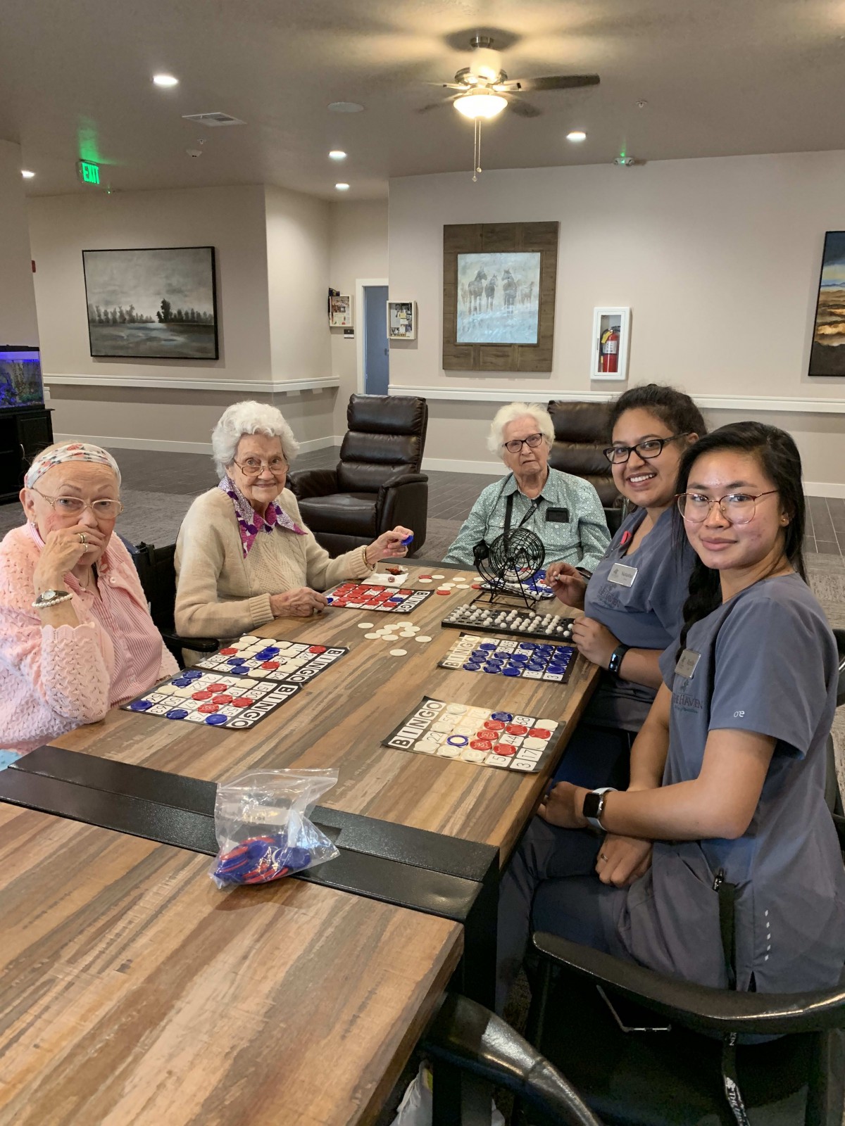 A group of people playing a game together at a table in a communal setting.