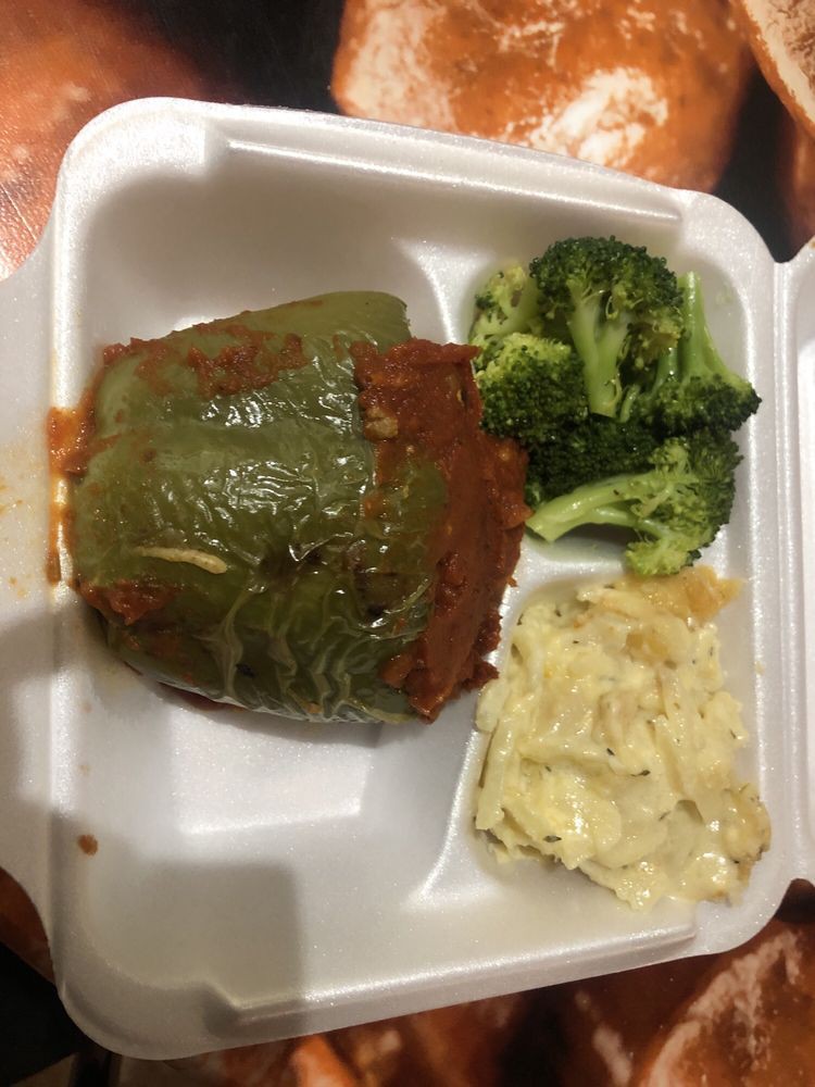 A takeout meal featuring a stuffed pepper, steamed broccoli, and macaroni and cheese.