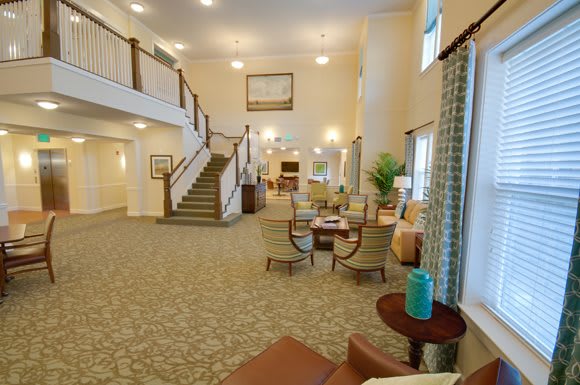 A spacious lobby with a central staircase and comfortable seating areas.