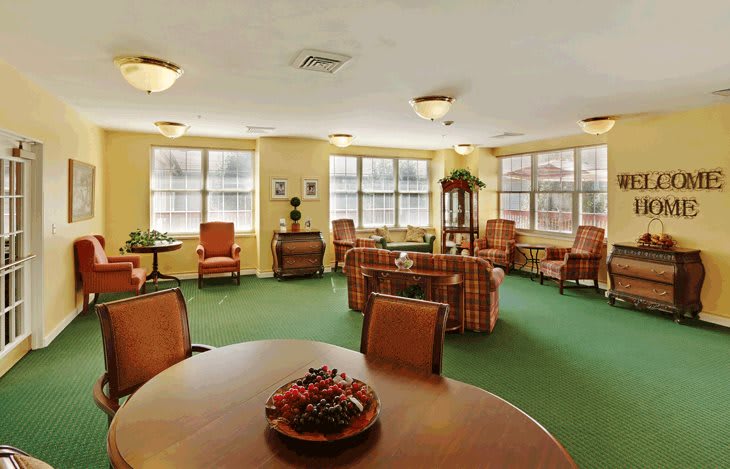 A cozy living room with multiple seating areas and ample natural light from large windows.