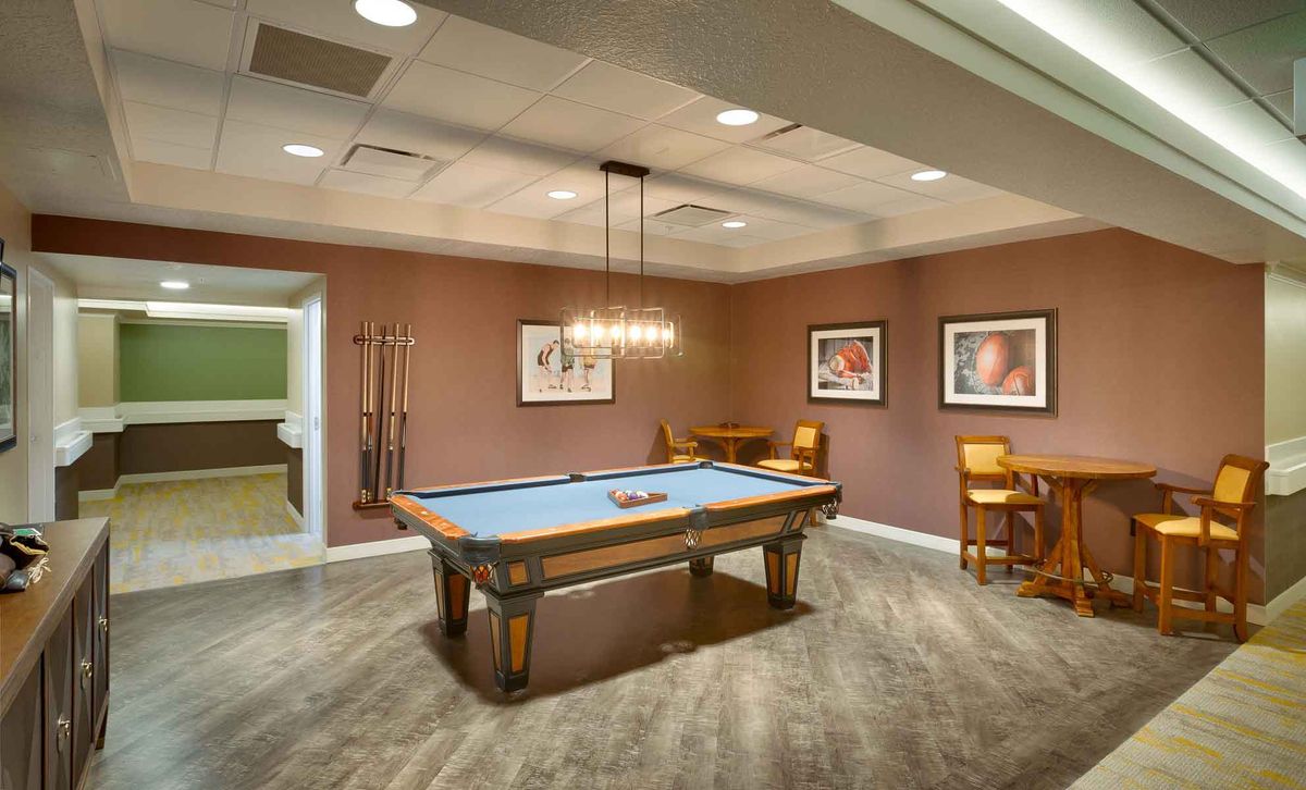 A cozy game room featuring a pool table and elegant lighting.