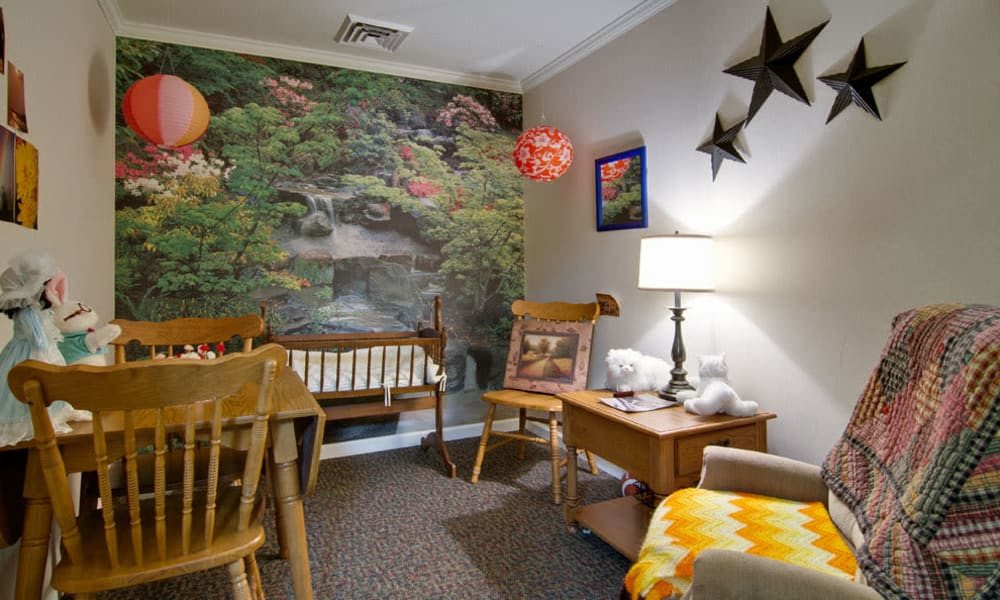 A cozy living room with wooden furniture, a nature-themed mural, and decorative lighting.