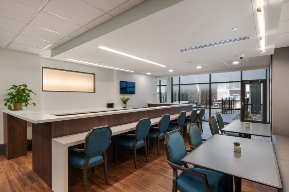 A modern office conference room with desks and chairs arranged for meetings.
