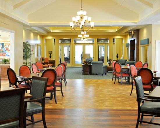 Elegant dining area with polished wooden floors and classic chandeliers.